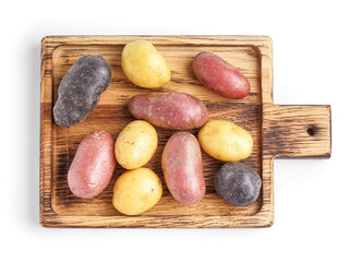 Wooden board with different types of raw potatoes on white background