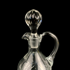 antique glass decanter with geometric pattern. retro decanter for alcohol on a black isolated...