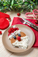 Plate with tasty Santa Claus pancake and Christmas decorations on wooden background