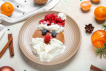 Plate with tasty Santa pancake and Christmas decor on light background