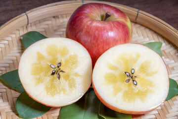 Honey Apple on bamboo basket, Apple with honey core on wooden background.
