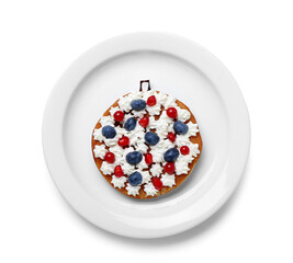 Plate with Christmas ball made of pancake, berries and whipped cream on white background