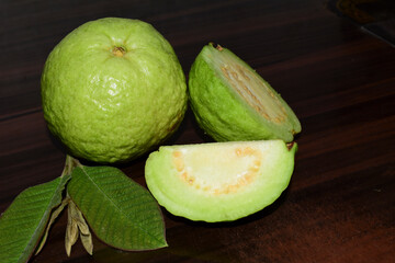 Fresh guava fruit with green leaf on the wooden table