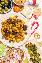Christmas table setting with tasty food and decor on white wooden background