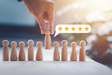 HR manager (human resources) or Employer hand choose takes person wooden doll. Leader stands out from crowd. Looking for good worker with 5 stars. HR, HRM, HRD concepts. © Pungu x