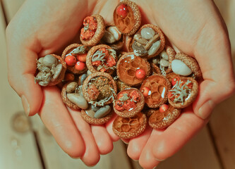 Close up woman showing souvenirs made of acorn caps concept photo. Top view person photography with...