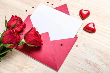 Blank letter with roses, candies and hearts on wooden background. Valentine's Day celebration