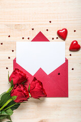 Blank letter with roses, candies and hearts on wooden background. Valentine's Day celebration