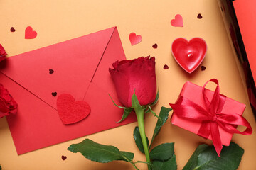 Envelope with rose, gift and hearts on beige background. Valentine's Day celebration