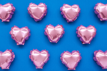 Pink heart-shaped balloons on blue background. Valentine's Day celebration