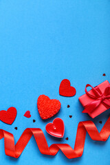 Candles, gift, hearts and ribbon on blue background. Valentine's Day celebration