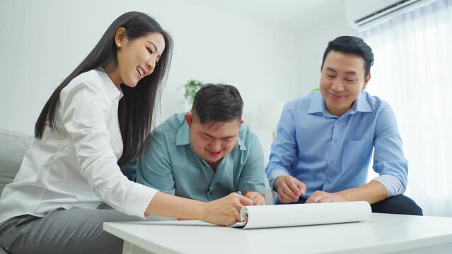 Asian happy family draw picture with young son in living room at home. 