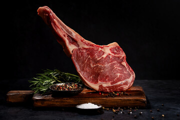 Raw Tomahawk beef steak and spices