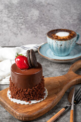 Chocolate and strawberry cake on a dark background. Biscuit prepared with special cream, chocolate and fruit cake with coffee. Bakery products