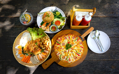 Pizza and Fried rice with Thai Foods on Wood Table.