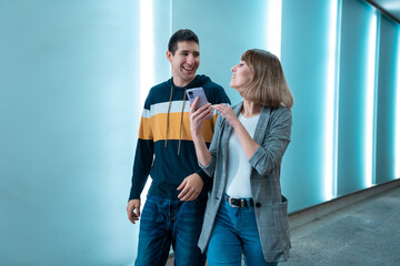 Obraz premium two young boys laughing talking with smartphone