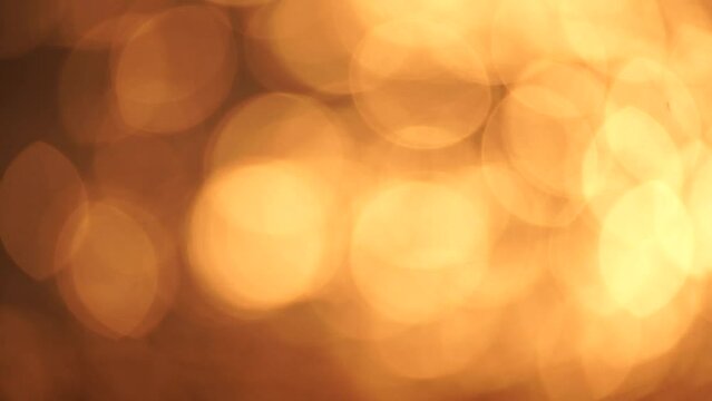 Blurred golden sea at sunset. The sun reflects and sparkles on the waves with bokeh, illuminating the golden sea. Holiday recreation concept. Abstract nautical summer ocean sunset nature background