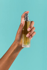 Crop black woman spraying perfume