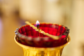 church lamp of red glass with oil and a burning wick close-up.