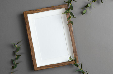 Blank wooden picture frame mockup with green plant decoration
