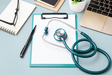 Doctor desk with green stethoscope and laptop