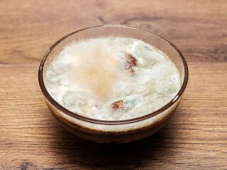 Mold on jam in a glass plate. Moldy food in the plate