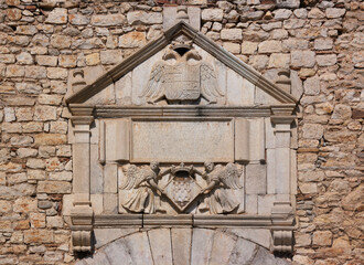 Renaissance pediment with coat of arms reliefs at Les Àligues university building in Girona,...