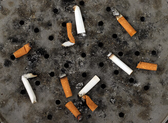 cigarette butts in metal ashtray
