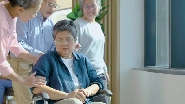 Side view of my friends senior woman and man consoling sad disabled senior woman sitting wheelchair at hospital, Consolation for better mental health, slow motion