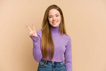 Young redhead woman cut out isolated showing victory sign and smiling broadly.