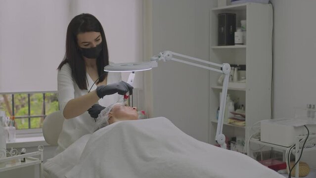 Close-up of a woman face. Needle mesotherapy procedure into the skin of the face