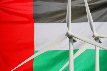 Two Wind Turbines for alternative energy on flag of United Arab Emirates background. Wind turbines...