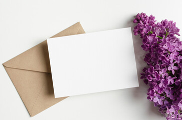 Blank wedding invitation card mockup with envelope and spring lilac flowers