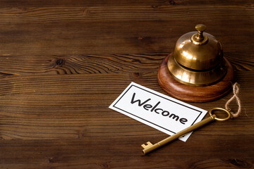 Hotel service bell on reception desk with welcome word on paper