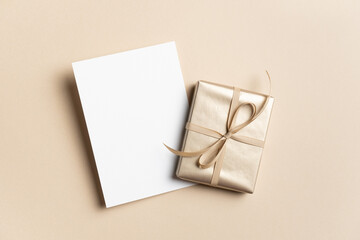 Blank greeting card mockup with golden gift box