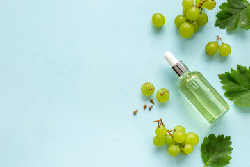Bottle of grape seed essential oil with grapes. Eco cosmetic product