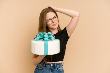 Young redhead woman holding a sweet cake isolated cut out