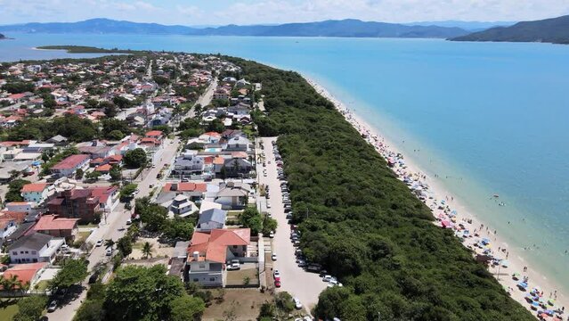 aerial drone scene of houses on the beach seen from above high standard houses facing the sea in florianopolis daniela beach with turquoise blue sea and lots of nature