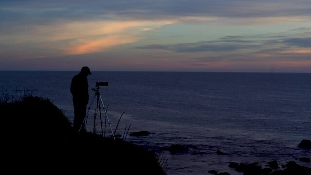 Silhouette of a Photographer Overlooking the Ocean at Sunset