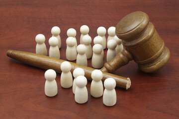Lawlessness and unfairness concept. Wooden people figures with broken judge gavel on table.	