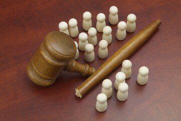 Many wooden people figures and broken judge gavel. Unfairness and injustice concept.