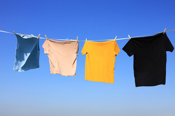 The wind blew clothes that had been dried in the sun and blown under the clear blue summer sky,...