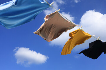 The wind blew clothes that had been dried in the sun and blown under the blue summer sky with...