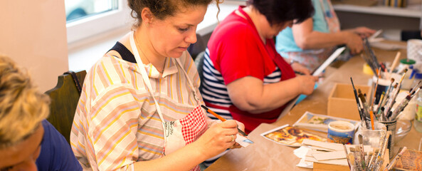 Women in art workshop making decoupage boxes	