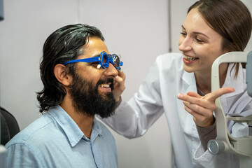 Obraz premium An eye doctor examines a male patient in a clinic with modern equipment.