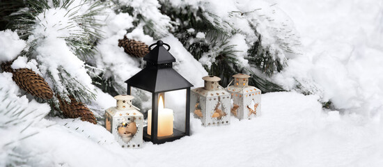 Lanterns in the snow under the Christmas tree