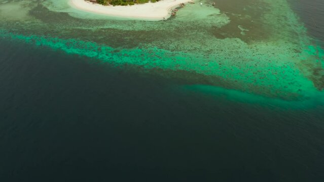Tropical island Mantigue and sandy beach surrounded by atoll coral reef and blue sea, aerial view. Small island with sandy beach. Summer and travel vacation concept, Camiguin Philippines Mindanao