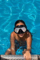 Naklejka premium High angle shot of a girl swimming in a pool while wearing a diving mask