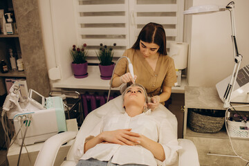 Close-up of woman getting facial hydro microdermabrasion peeling treatment. Female at cosmetic beauty spa slinic. Hydra vacuum cleaner. Cosmetology