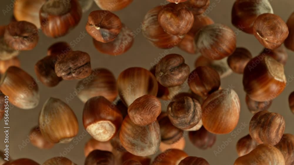 Poster super slow motion of rotating hazelnuts up to the air. filmed on high speed cinema camera, 1000fps, 